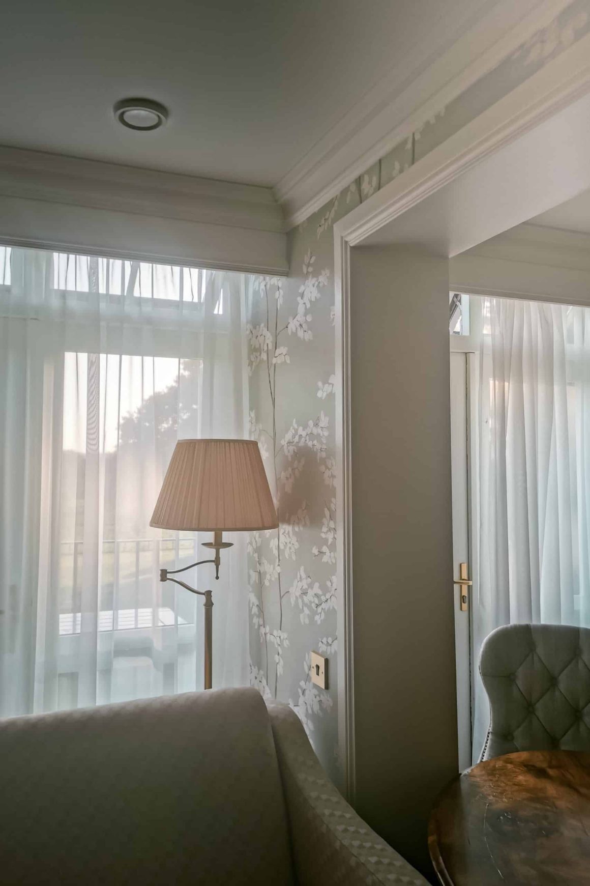 Sunlit seating area with large windows and stylish furnishings inside a suite at Cahernane House Hotel.