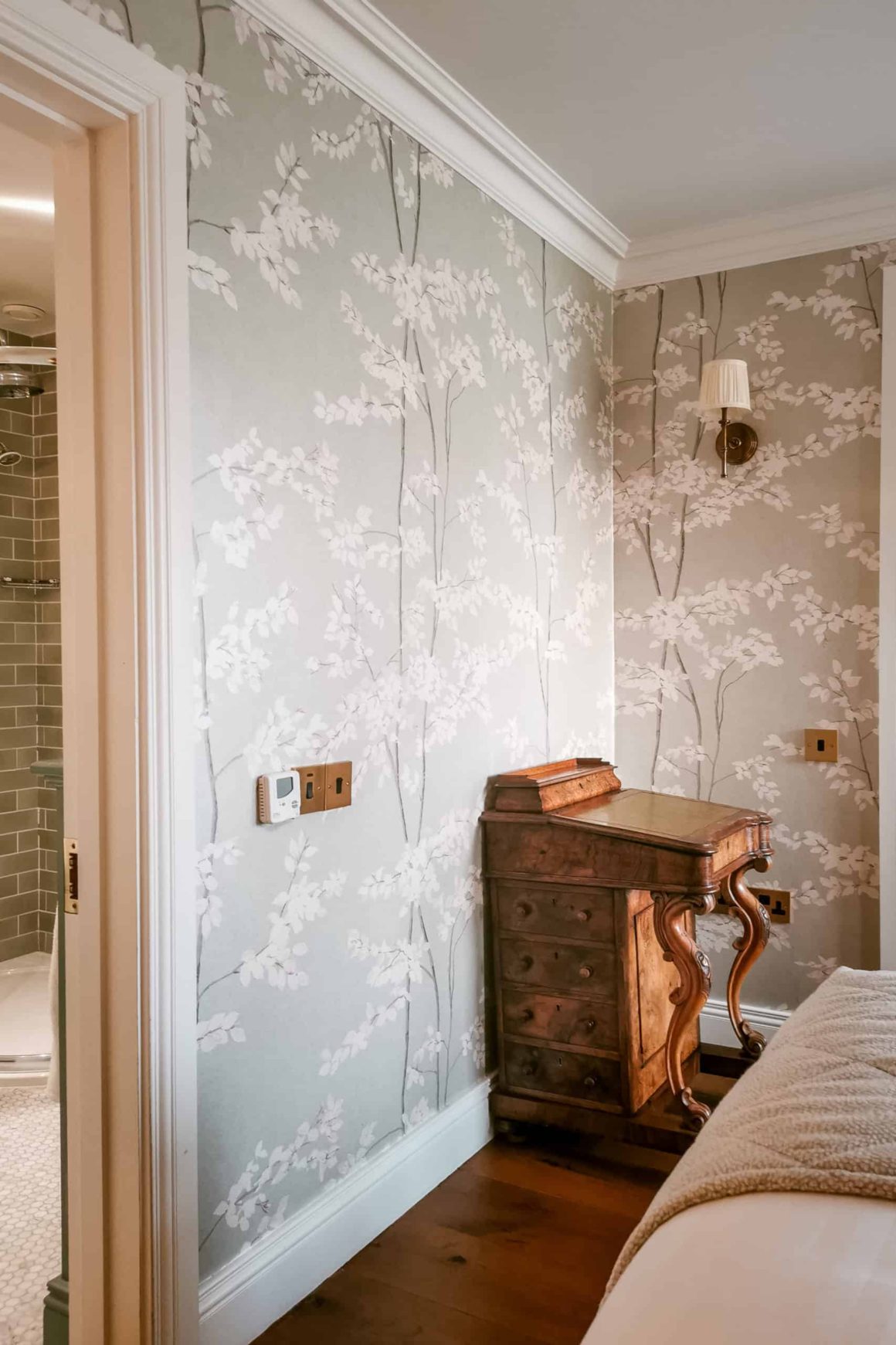 Classic wooden writing desk and floral wallpaper beside the bedroom at Cahernane House Hotel in Killarney.