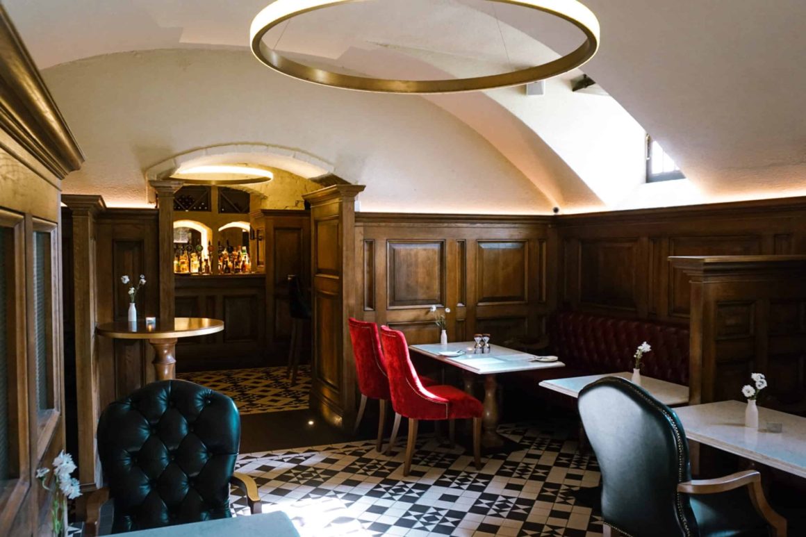 The cellar bar at the Cahernane House hotel with single cushioned chairs covered in red and black leather