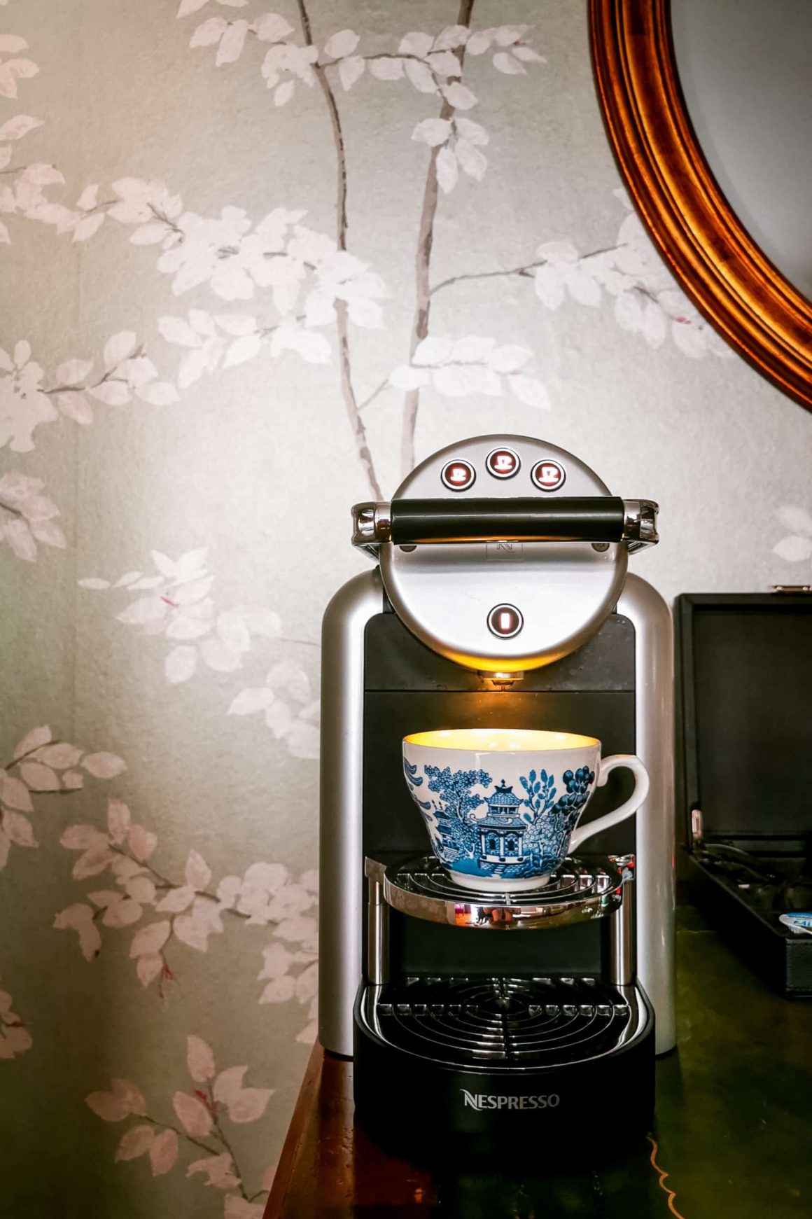 Nespresso coffee machine with a decorative teacup providing premium in-room refreshments for hotel guests.