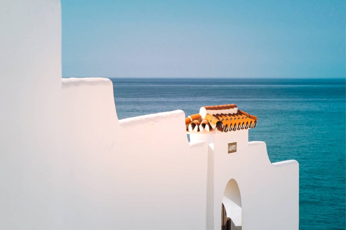 Whitewashed wall of Nerja town against backdrop of sea