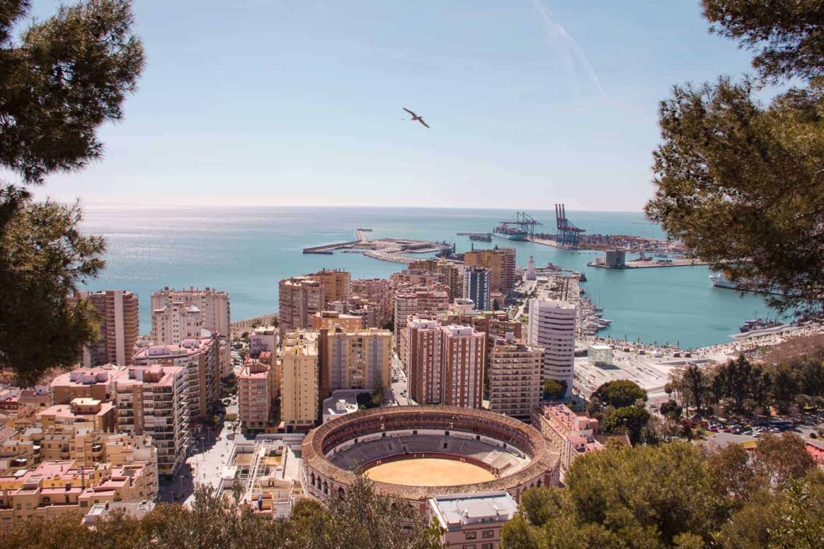 Elevated view over Mรกlaga featuring the bullring, city buildings, marina and Mediterranean Sea.
