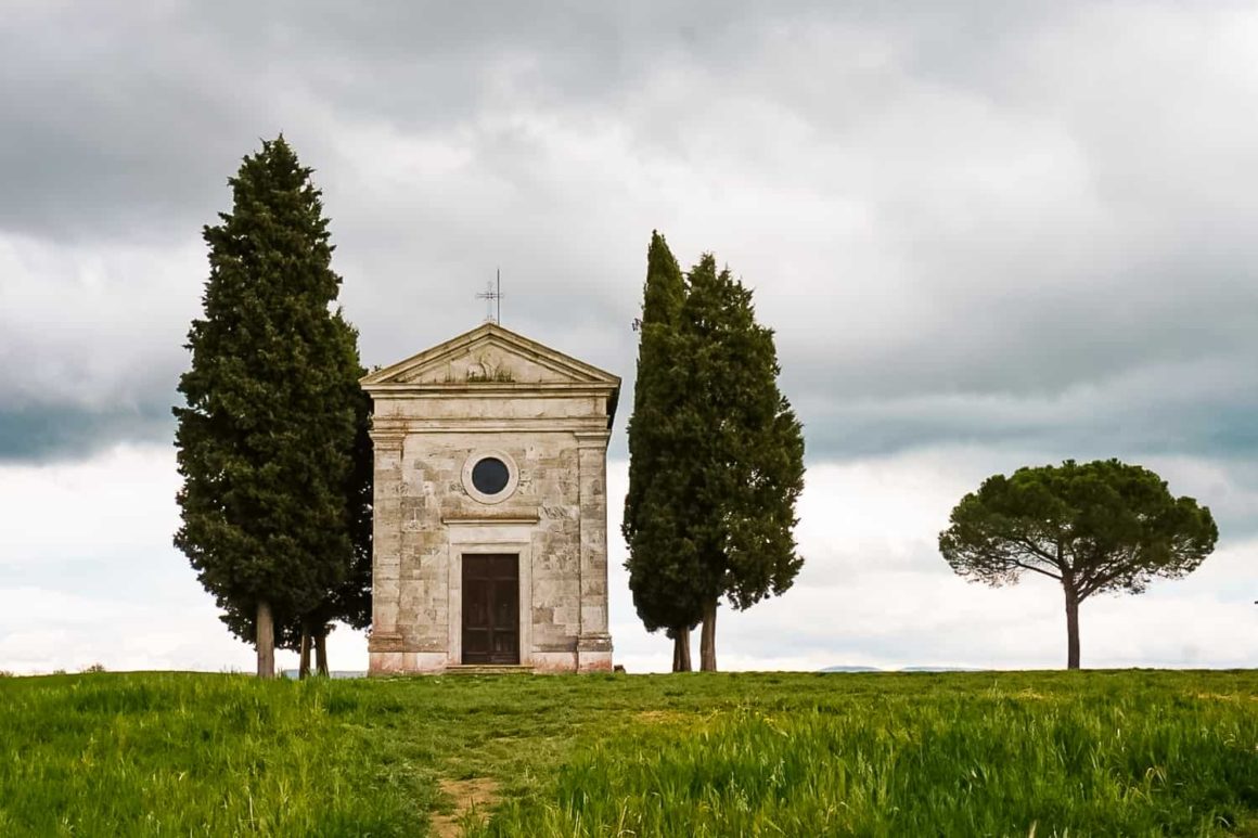 Rolling green hills and the Chapel of the Madonna di Vitaleta in Val d'Orcia, featured in this Tuscany travel guide