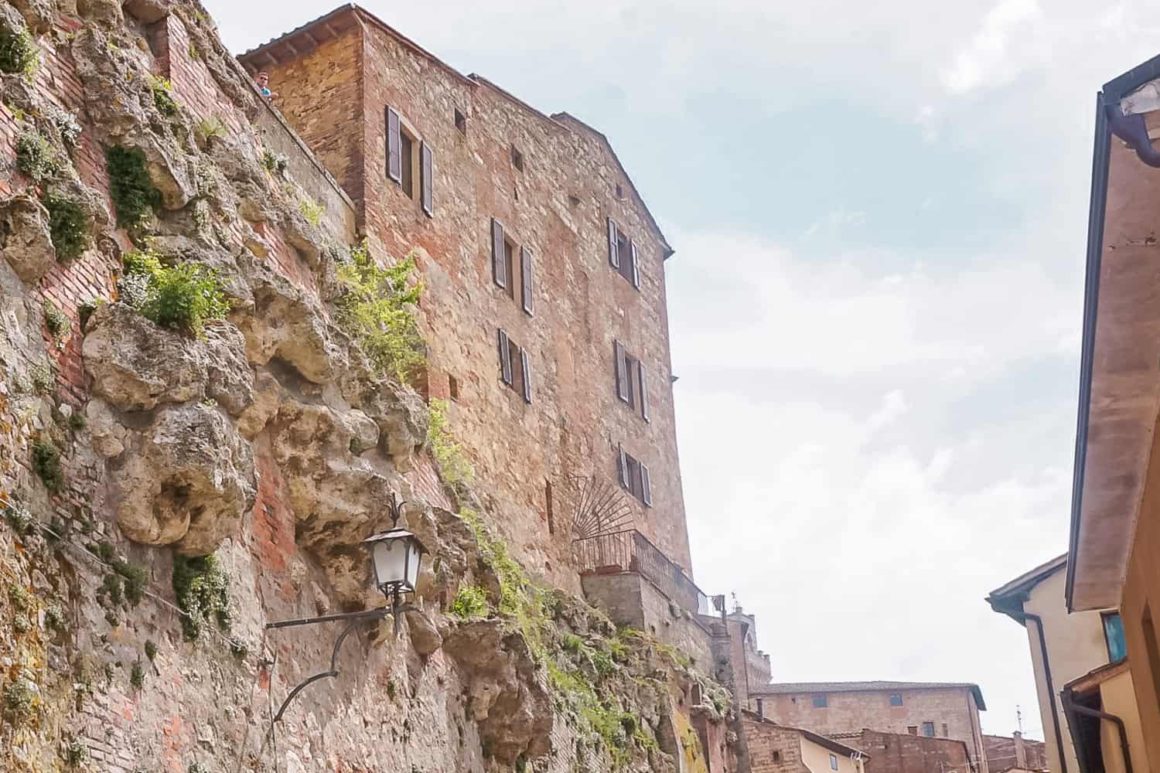 Ancient stone buildings perched above rugged rock formations in the hill town of Pitigliano