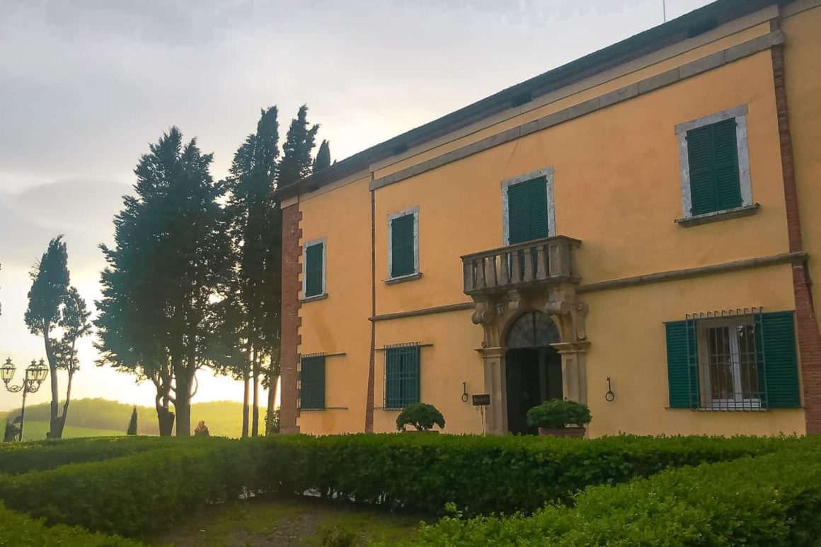 Elegant Tuscan villa with green shutters glowing in the evening light