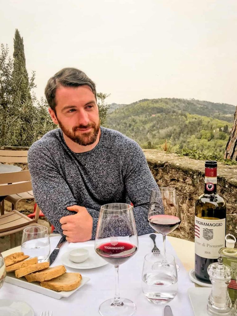 Traveller enjoying a glass of Chianti wine during lunch at a Tuscan vineyard