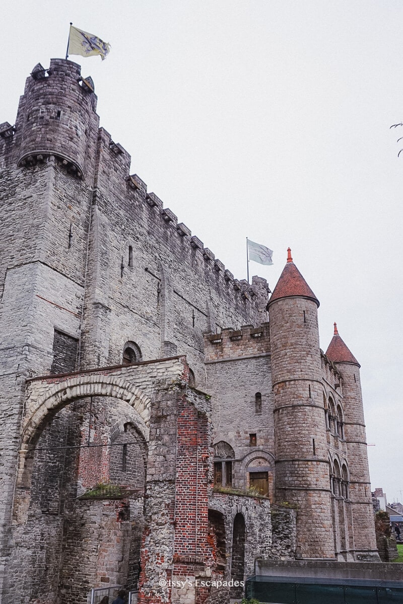 castle walls with flag blowing at one of ghent tourist attractions, the gravensteen