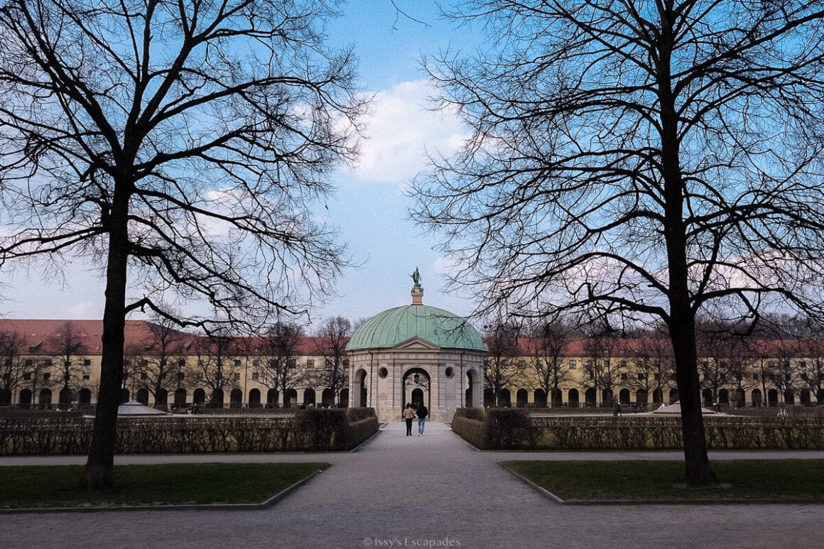 Tree-lined pathway leading towards the domed Diana Temple in the Hofgarten in Munich.