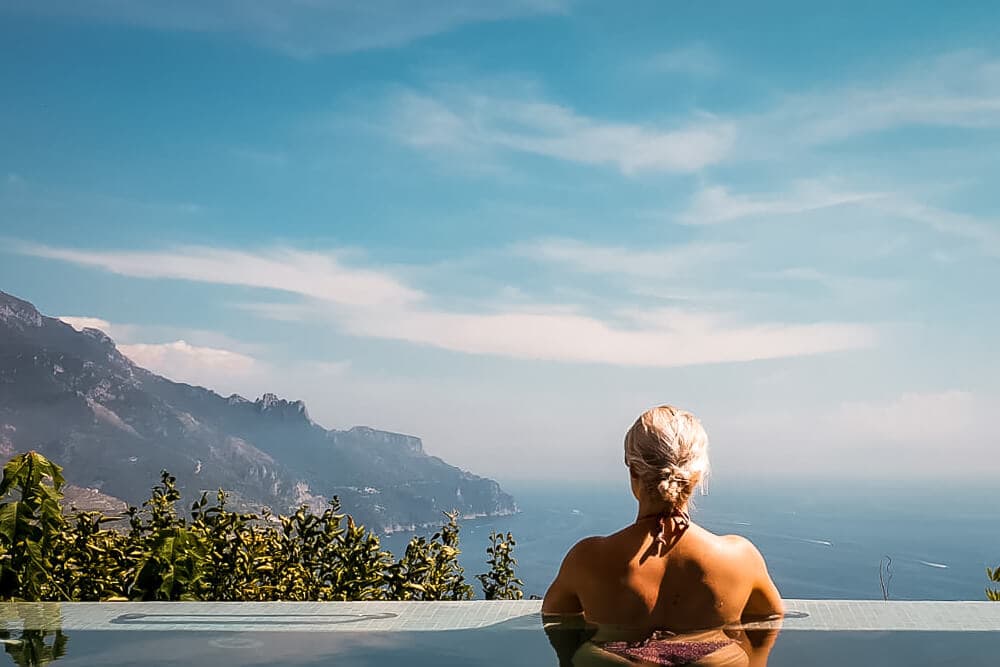 blonde girl looks out from pool on Amalfi Coast
