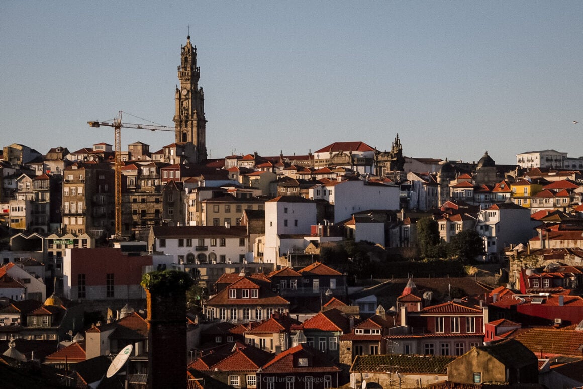 a view of a city with a clock tower of the Clerigos Tower in the background.