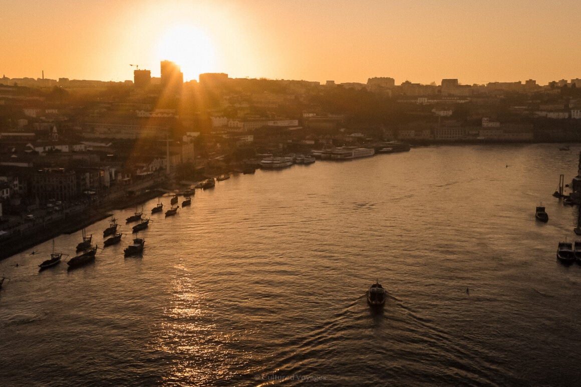 Yellow sunset on the horizon with the city in the dark and a river boat in the foreground