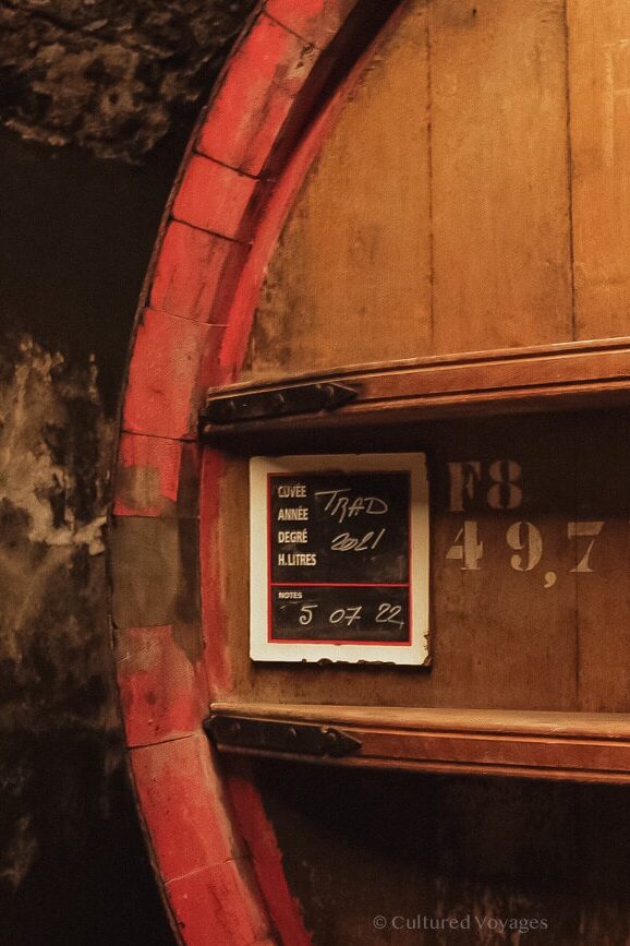 A close up of one side of a big wine barrel with a number in white paint and a label