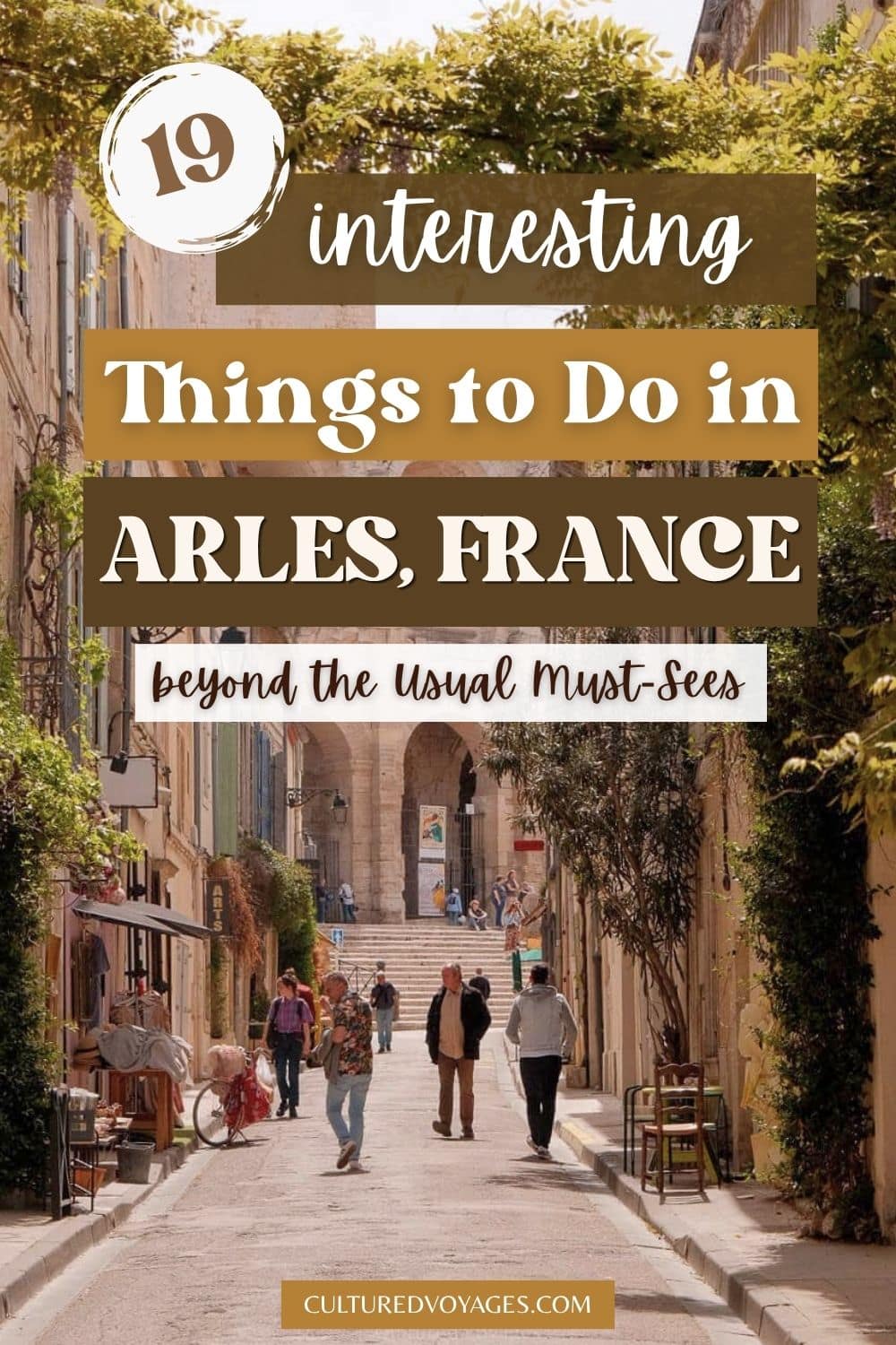things to do in arles pinterest pin cover, A sunlit historic street in Arles, France, lined with old buildings, greenery and pedestrians. The image highlights things to do in arles for travellers exploring Provence.