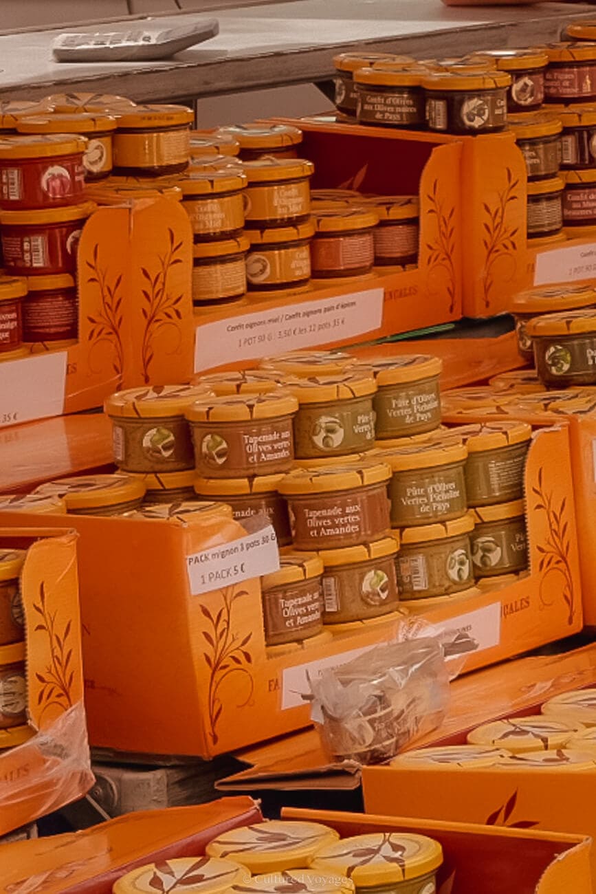 A stack of glass canned items inside open orange boxes with labels on them