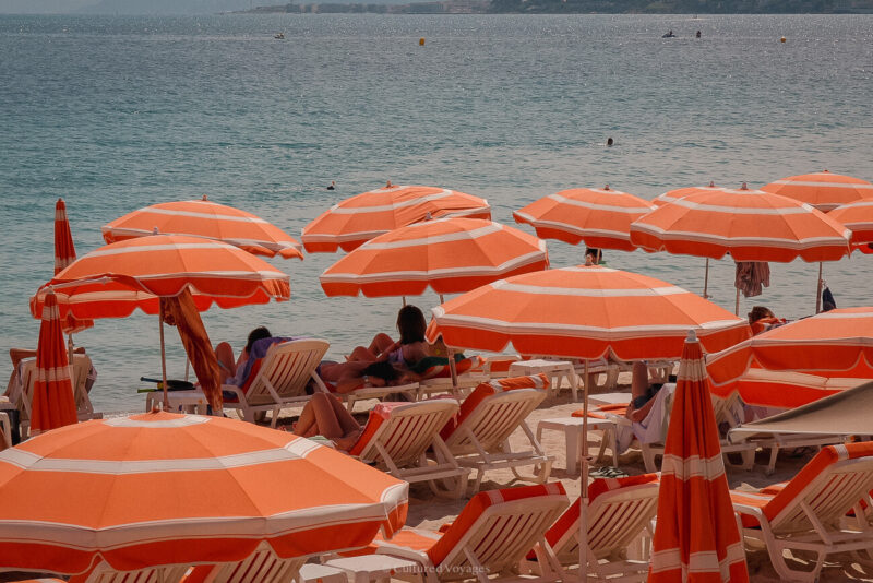Orange-and-white parasols beside the clear blue Mediterranean in Antibes