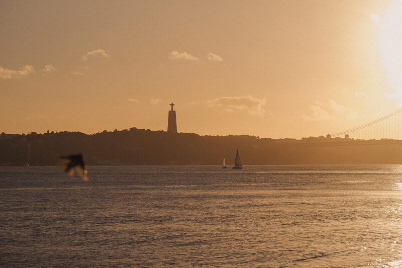 Sailboats on the Tagus at sunset, with Cristo Rei on the opposite bank
