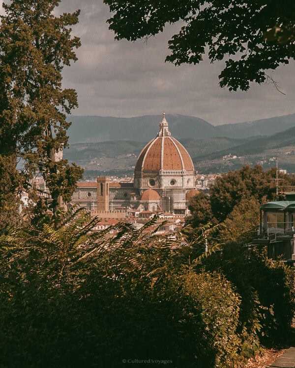 The iconic dome of Florenceโs Duomo viewed from a leafy vantage point, showcasing why this serene moment is considered the best time to visit Florence.