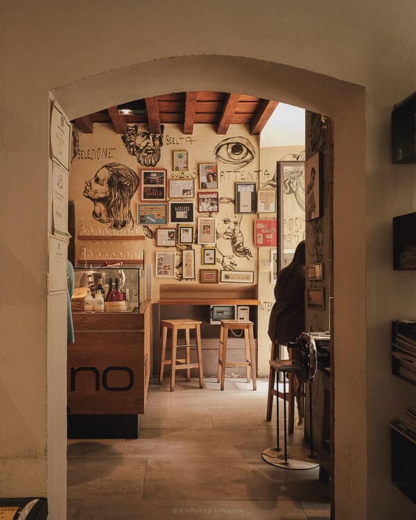 A cosy, art-filled cafรฉ interior with rustic walls and bar stools, offering a glimpse into the cityโs intimate coffee culture.