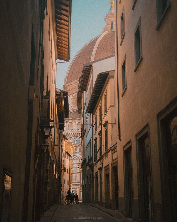 Florenceโs Duomo viewed from a narrow alley, bathed in early morning lightโone of the best times to visit Florence for peaceful exploration.