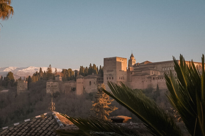 The Alhambra above Granada’s rooftops with snowy mountains behind