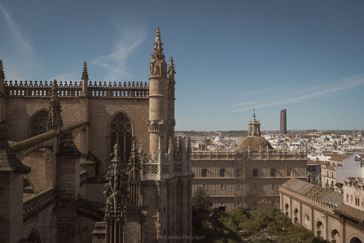 The ornate spires and Gothic details of Seville Cathedral rise against a bright blue sky, offering a captivating sight in one of the best European cities to visit in winter.