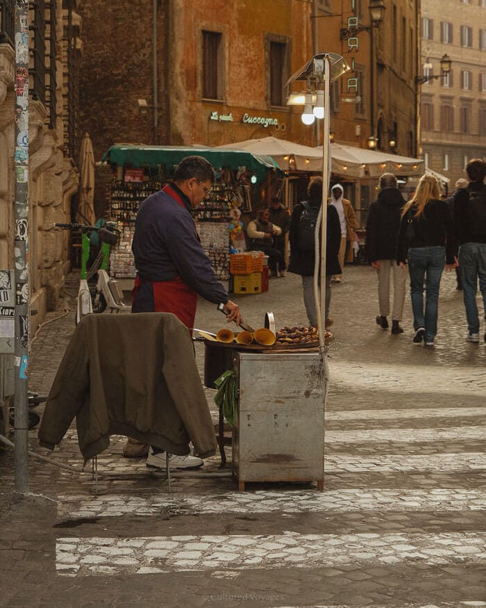 A local vendor roasting chestnuts on a cobbled street in Rome, a beloved winter tradition that adds to the city’s festive atmosphere.