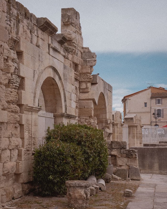 Weathered stone arches and remains of a Roman amphitheatre under a soft winter sky in southern France, highlighting one of the best European cities to visit in winter.