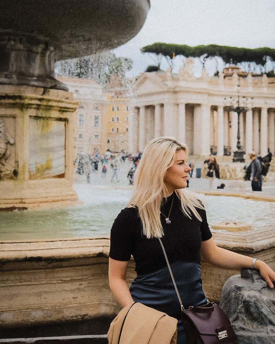 Isabelle Hoyne beside a fountain in St Peter's Square, Rome, with Bernini's colonnade behind