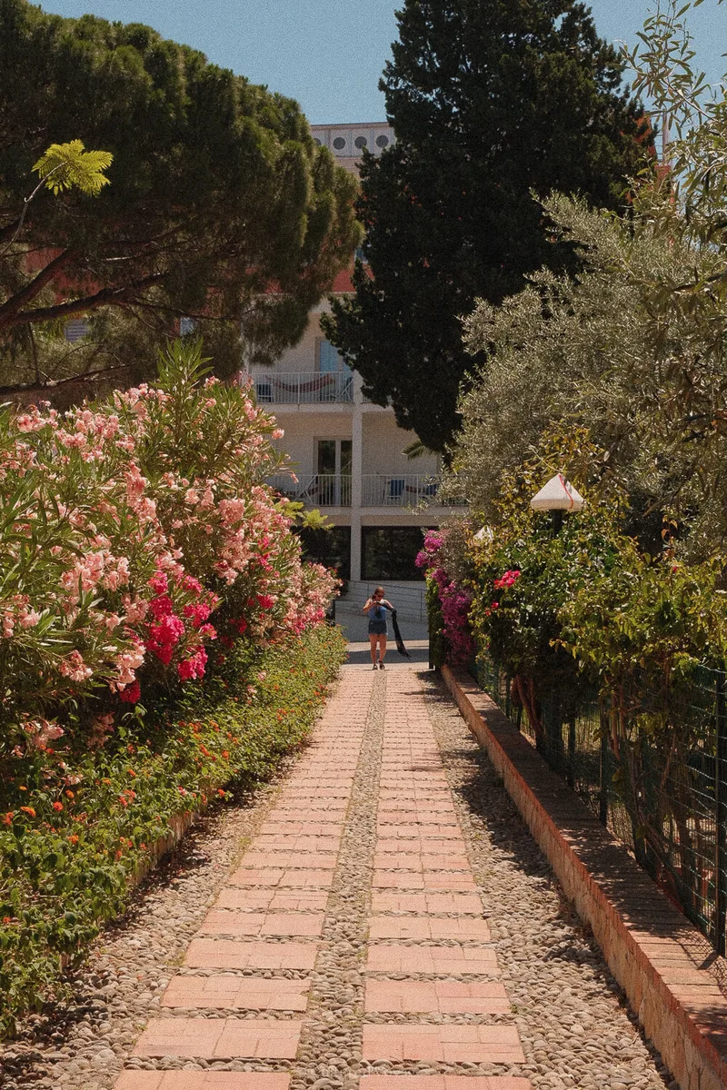 Flower-lined path leading towards Hotel Kalura in Cefalù, Sicily.